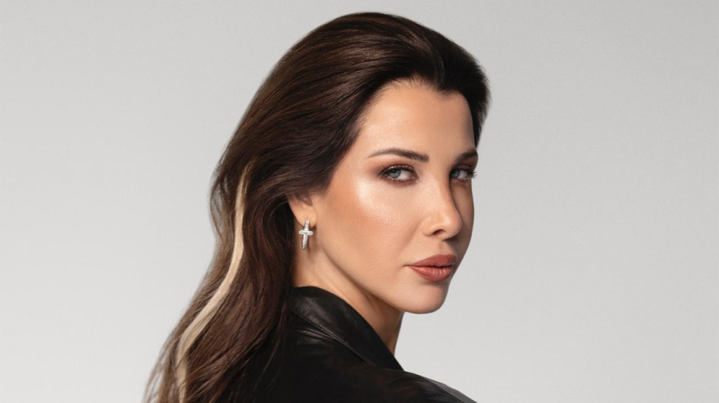 Singer Nancy Ajram with a serious pose against a plain background.