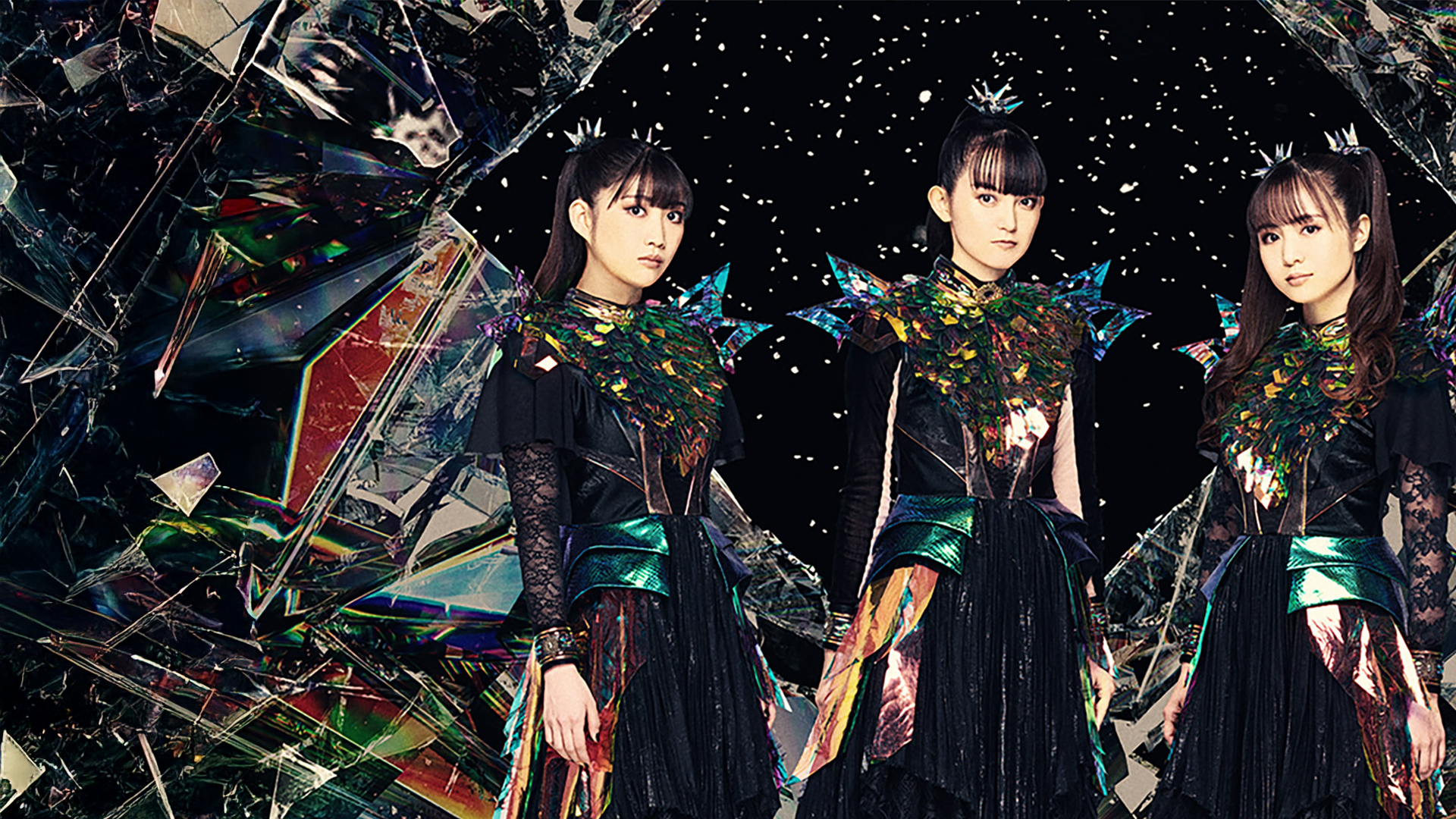 BABYMETAL band members in striking black and blue outfits stand in front of a fractured mirror.