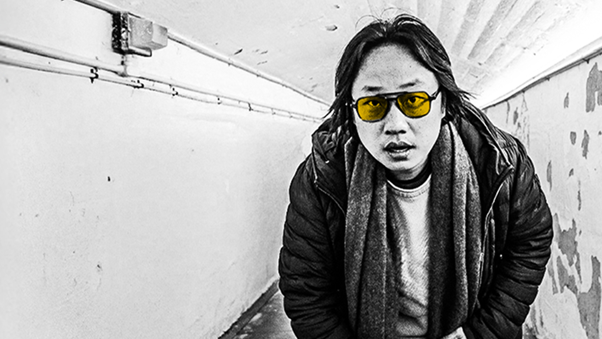 Jimmy O. Yang standing in an underground subway posing for the camera.