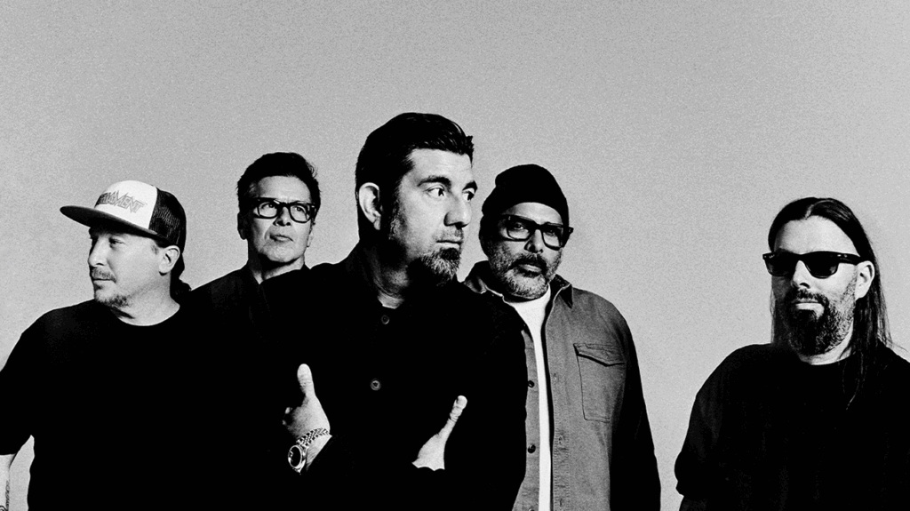 Deftones band members dressed in casual clothing and posing in a black and white photo.