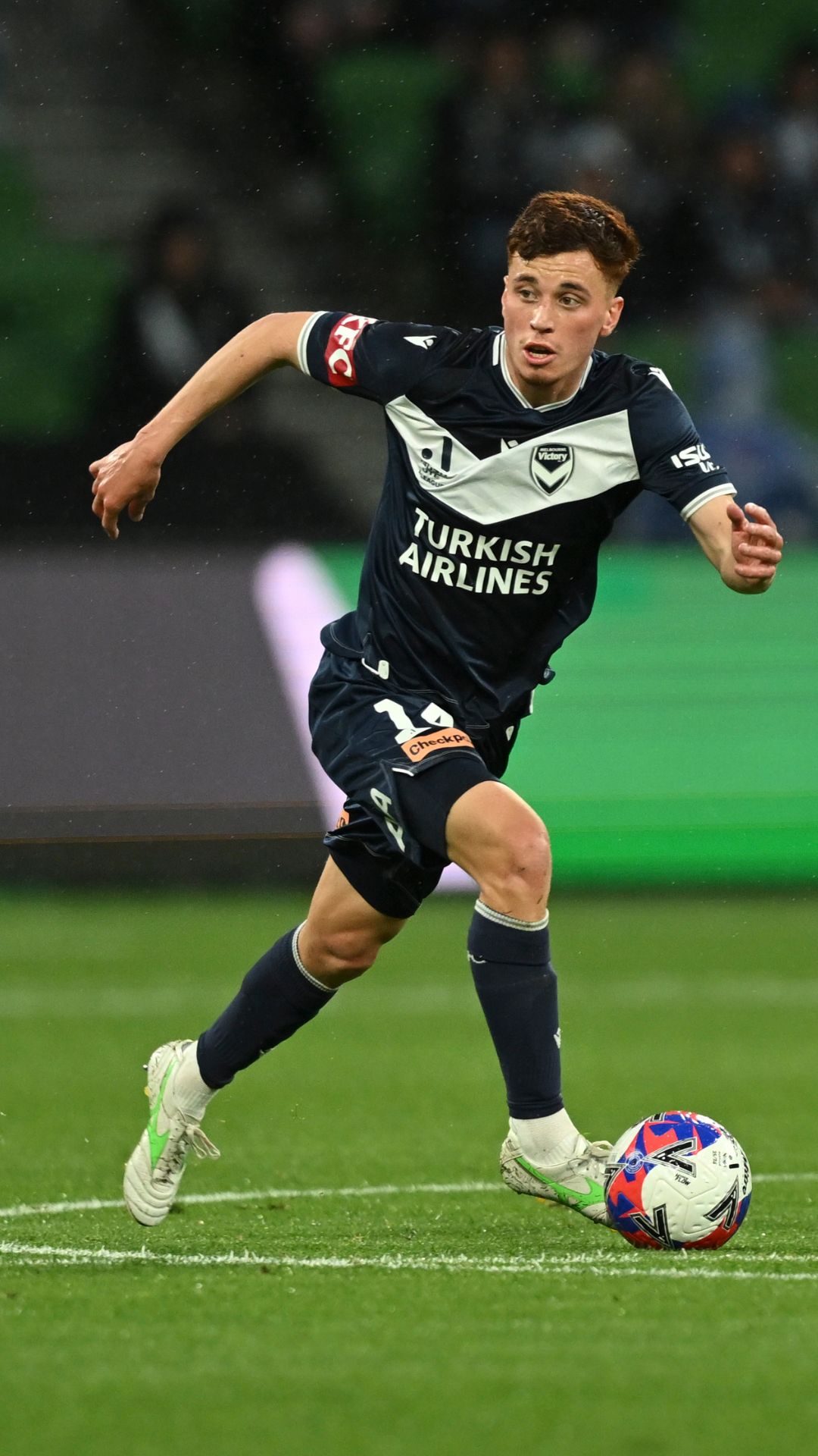 Melbourne Victory footballer dribbling a ball.