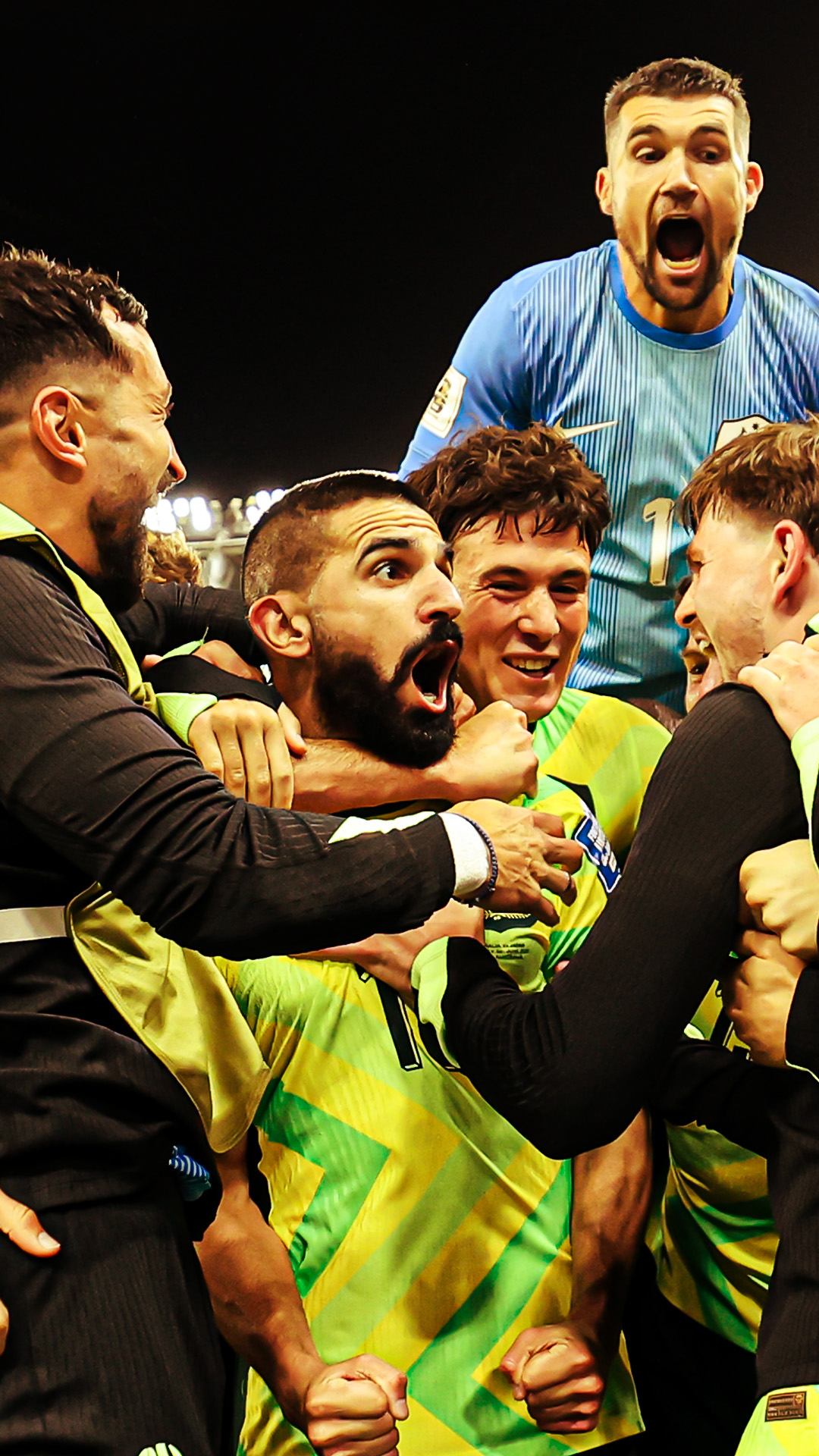 Socceroos footballers celebrating a soccer victory in a stadium.