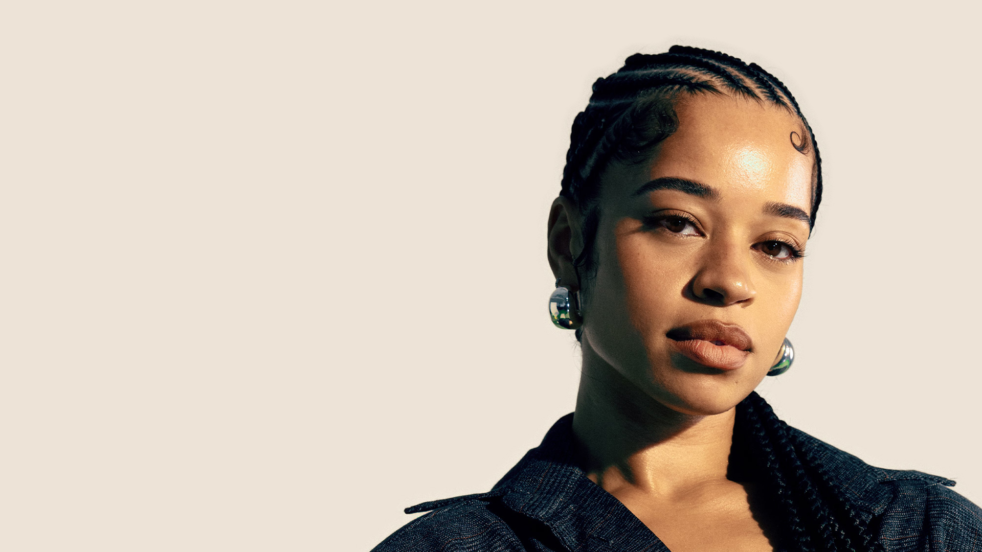 Ella Mai poses with her hair styled in braids.