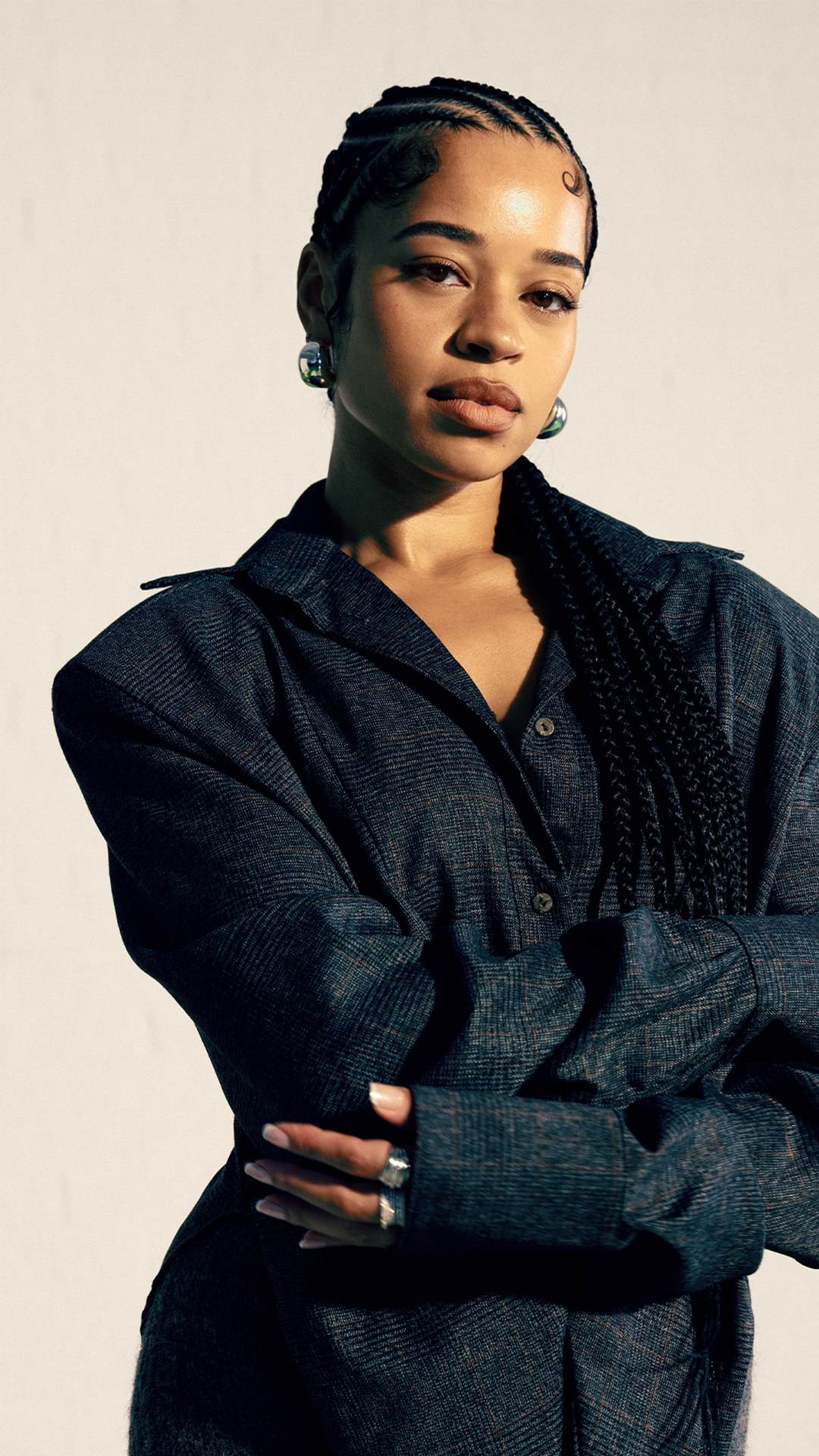 Ella Mai poses with her hair styled in braids.