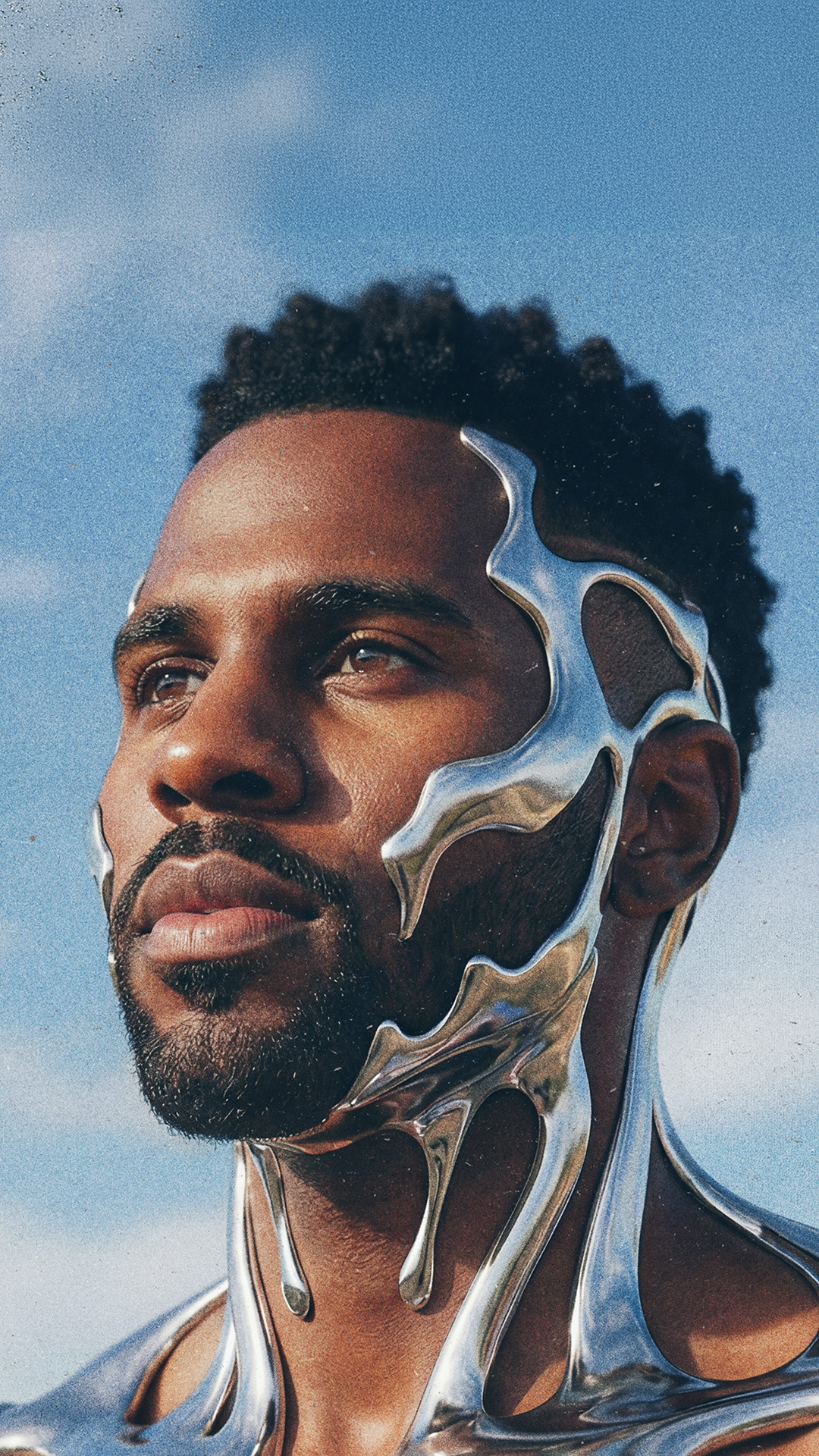 Jason Derulo depicted with a silver face and body, poses confidently against a blue sky background.