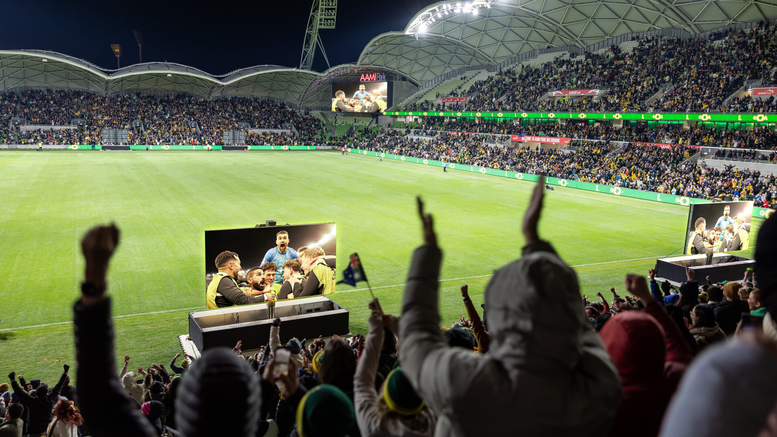 Packed crowd enjoying a football live site in a stadium.