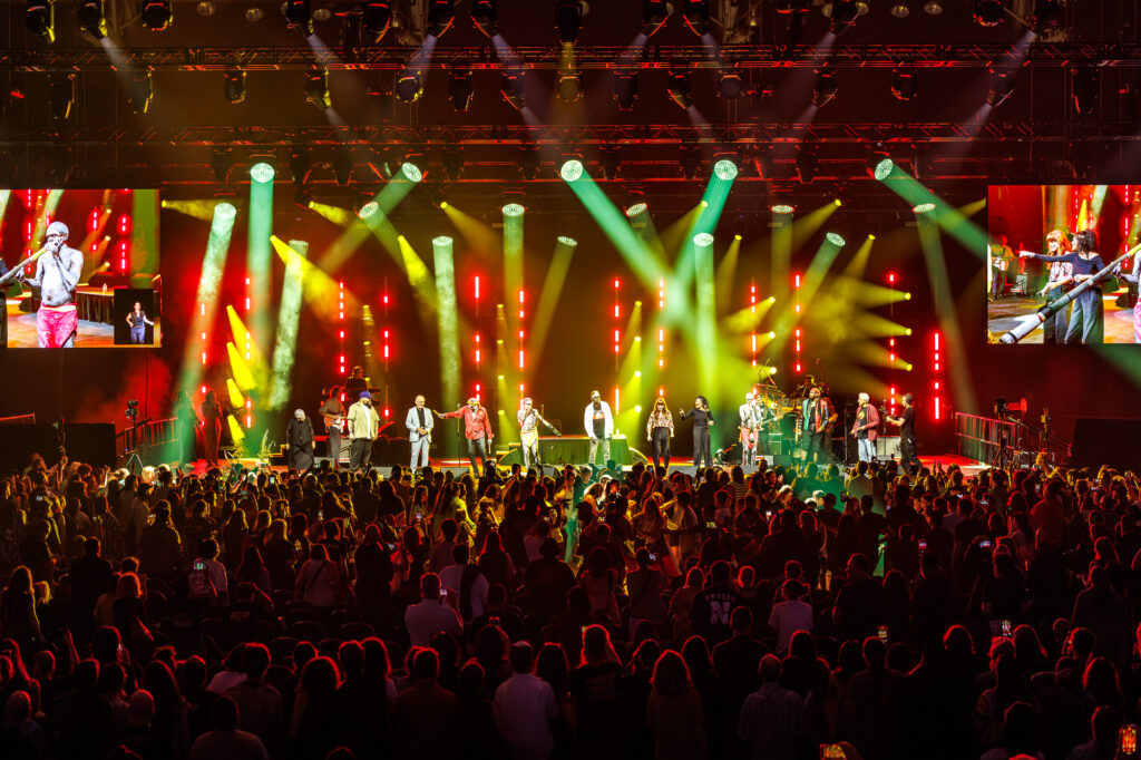 Artists and musicians together on stage at a concert event.