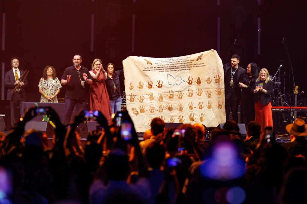 Delegates and representatives on stage showcasing a Treaty.