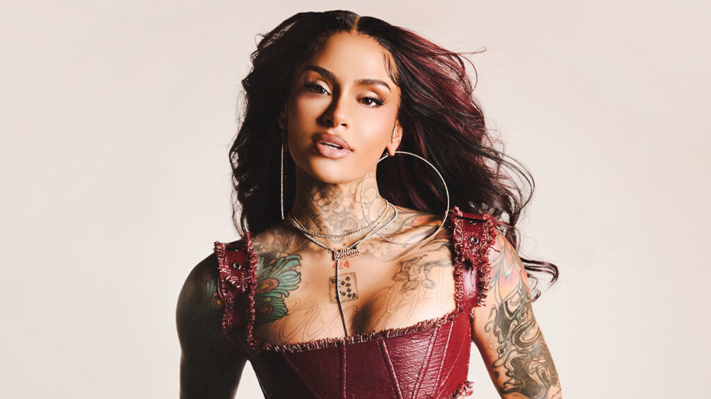 Kehlani wearing a red dress, posing confidently against a neutral background.