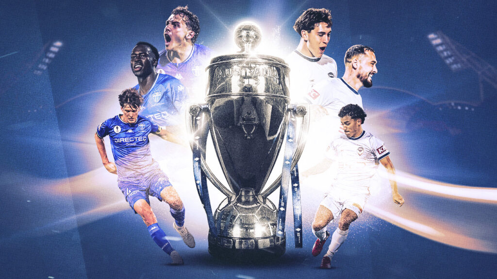 Soccer players celebrate in front of a large trophy.