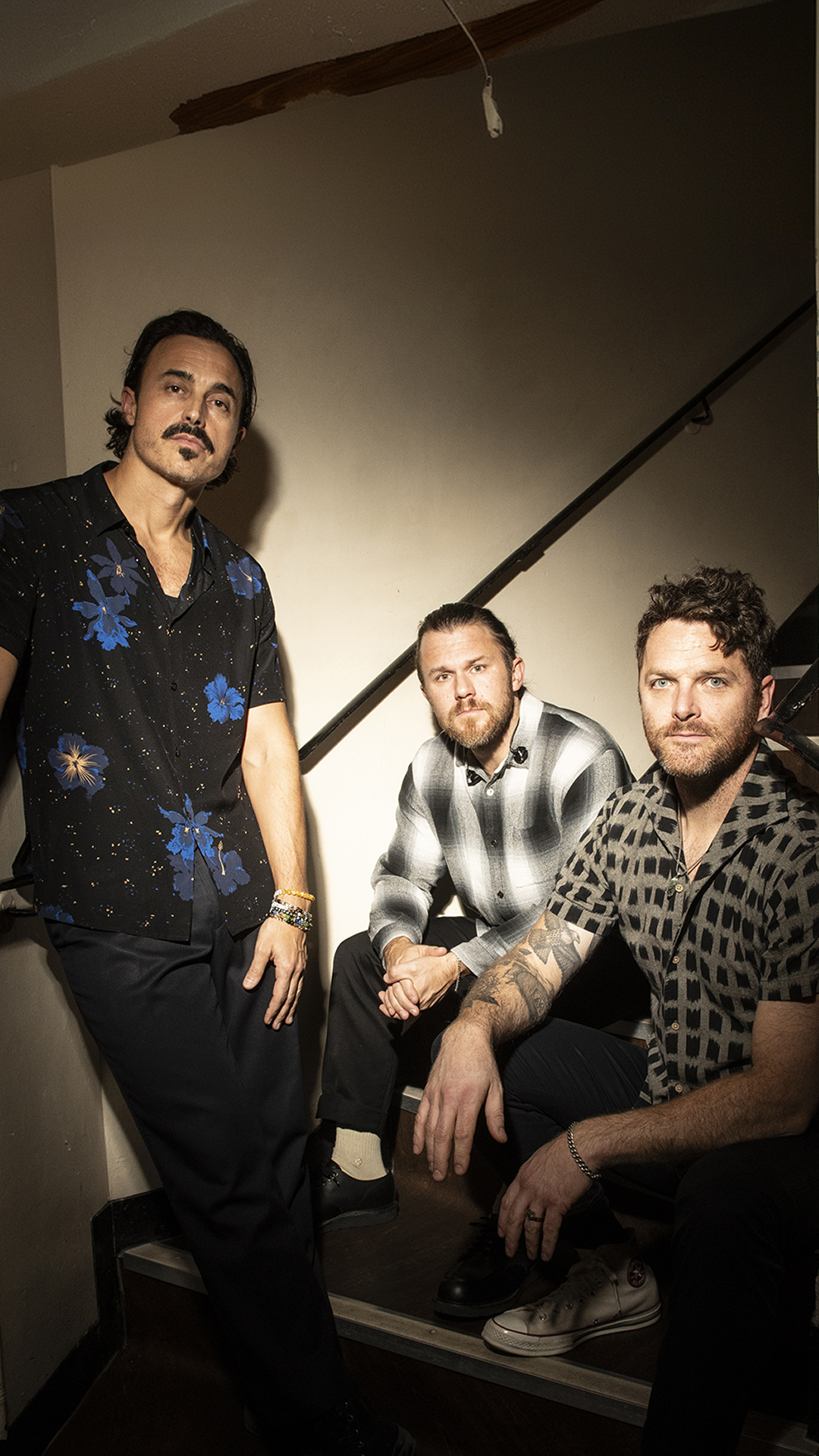 The Fray band members with serious poses against a stairwell.