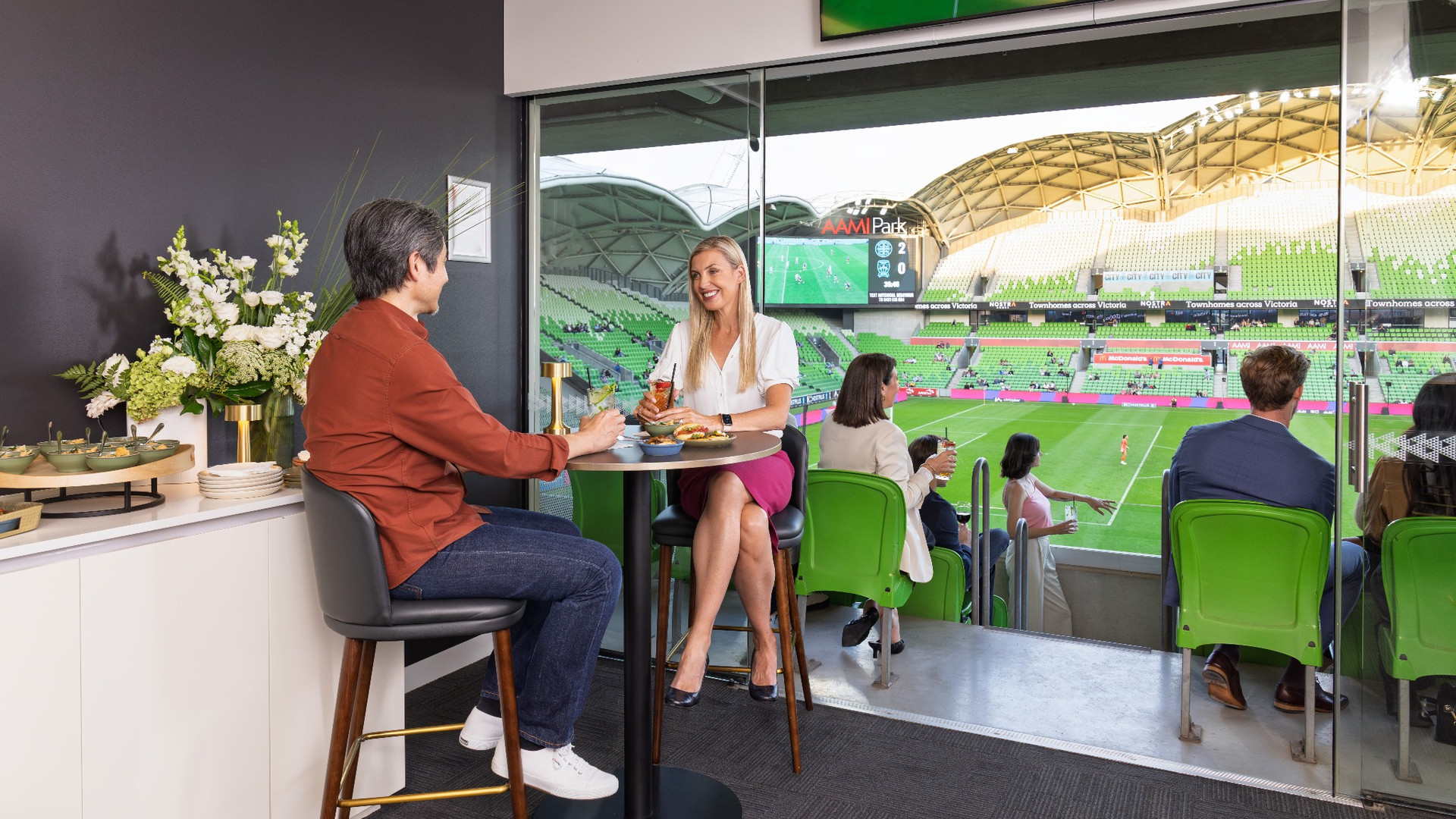 People chatting in a corporate box.