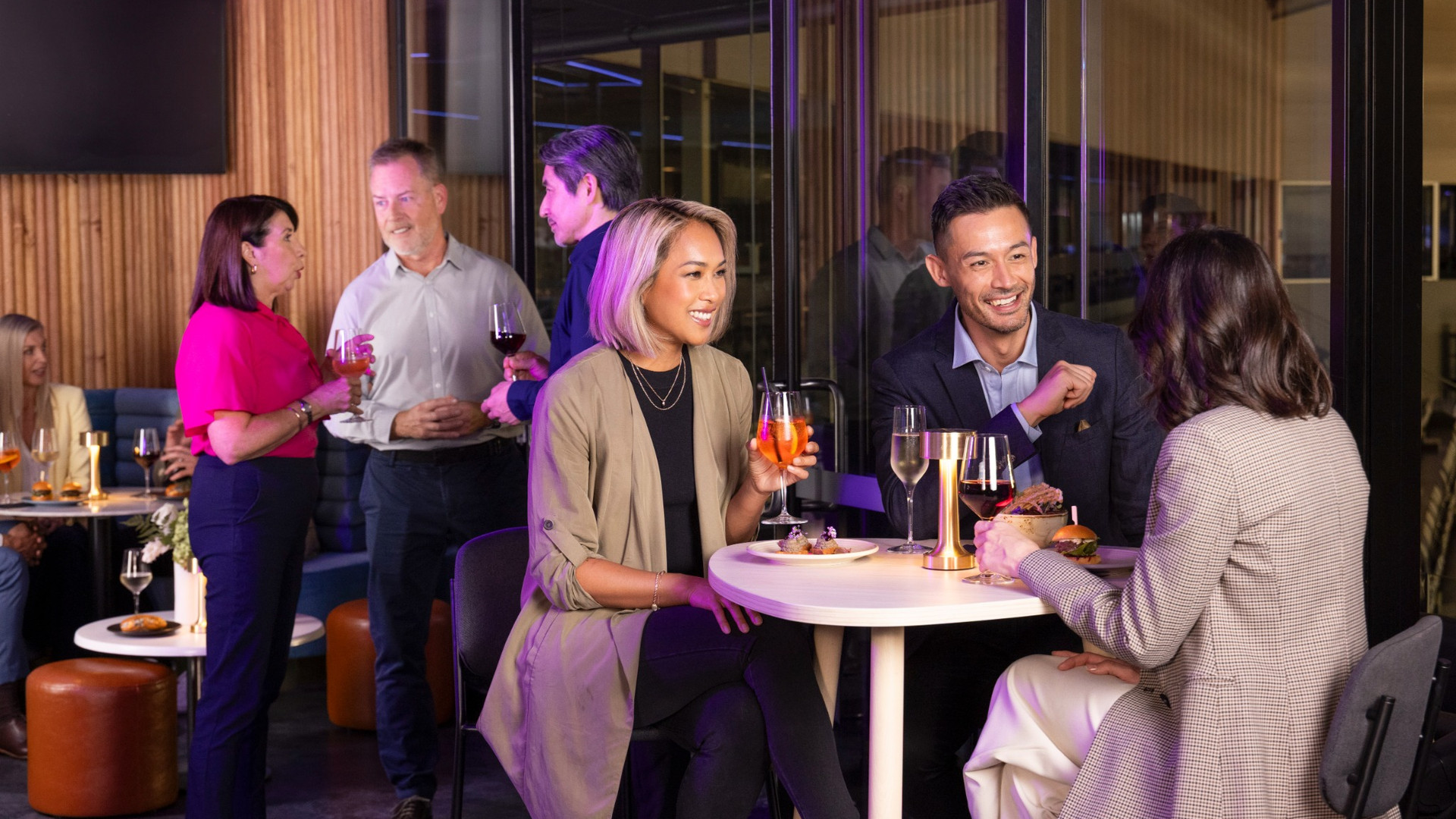 Crowd raising their drinks in a corporate box.