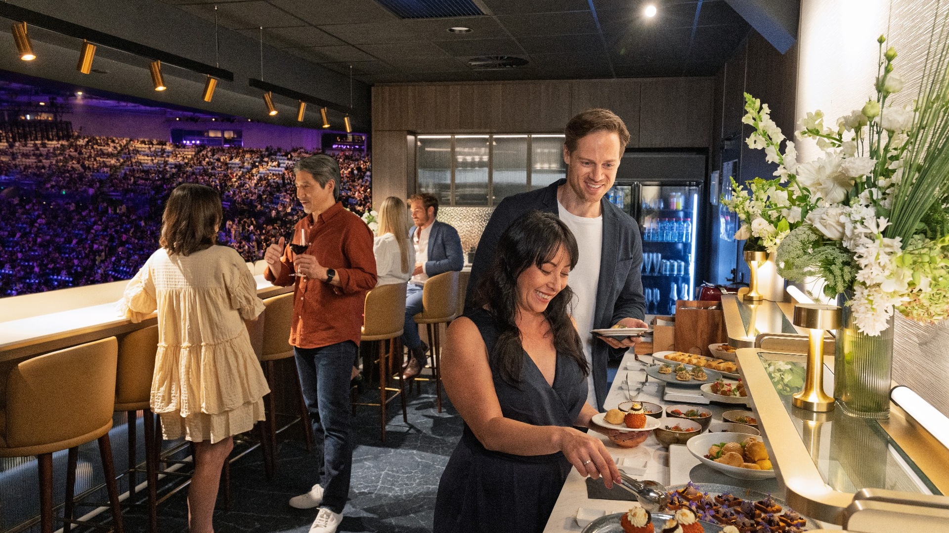 Crowd picking from a food buffet in a corporate box.